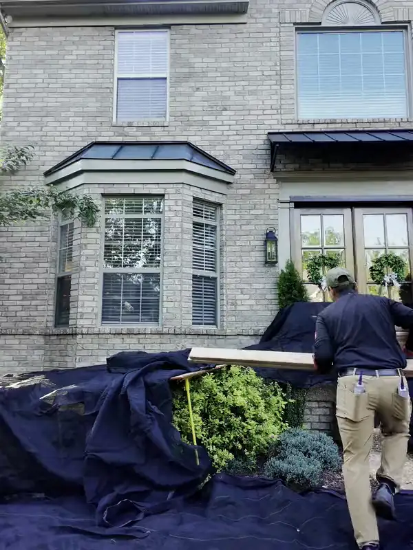 The Hisway crew covering the beds and shrubs in front of a home before a roof replacement